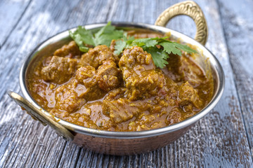 Traditional Indian Lamb Curry as close-up in a Korai