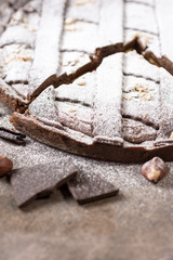 Chocolate Tart Pie Topped with Hazelnuts and Sprinkled with Powdered Sugar