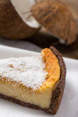 Coconut Tart Pie Slice on White Paper and Wooden Table Background