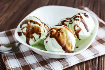 Pistachio ice cream with chocolate on a rustic background