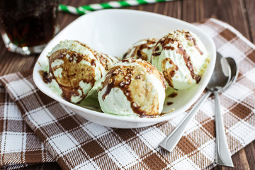 Pistachio ice cream with chocolate on a rustic background