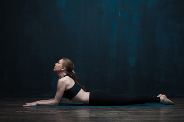 Fototapeta na wymiar Side view of flexible woman doing yoga indoors