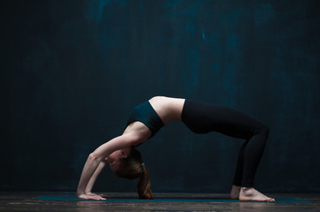 Flexible woman practicing advanced yoga asana