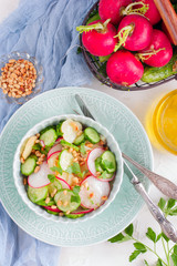 Salad from potatoes, radishes, cucumbers with pine nuts, top view