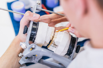 Prosthetic dentistry technician working in his office, manufacturing ceramic crowns