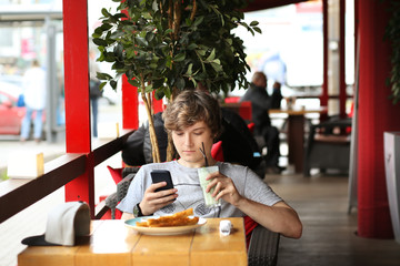 Lifestyle portrait of a young man using a smart phone outdoors