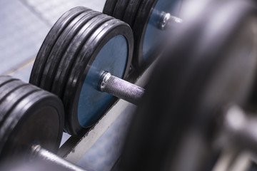 Fototapeta na wymiar Close up. Old school gym interior with equipment, bodybuilding background. Heavy iron dumbbells stacked in rows.