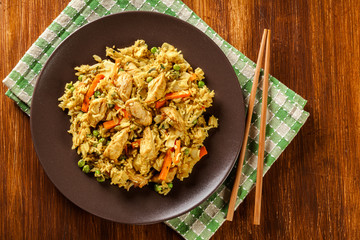 Fried rice nasi goreng with chicken and vegetables on a plate