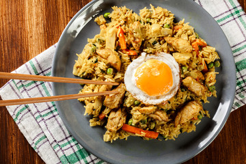 Fried rice nasi goreng with chicken egg and vegetables on a plat