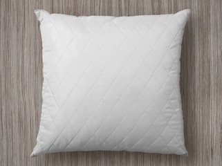 white pillow on wooden floor