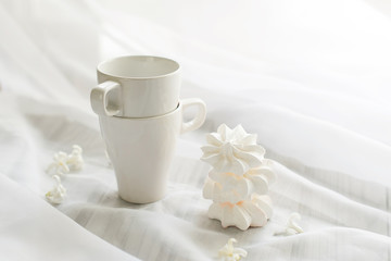 White meringues and two white cup