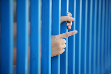 Obraz premium hand of prisoner in jail as background.