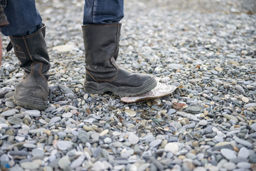 Close up of feet in black boots on pebble
