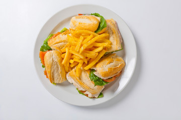 Different types of sandwiches with French fries on a white plate