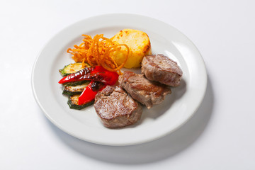 fried steaks with potatoes, peppers and zucchini