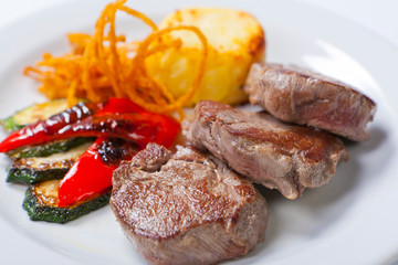 fried steaks with potatoes, peppers and zucchini