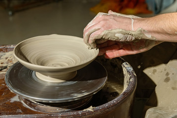 Hands working on pottery wheel