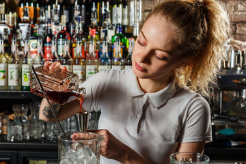 Woman bartender making an alcohol cocktail