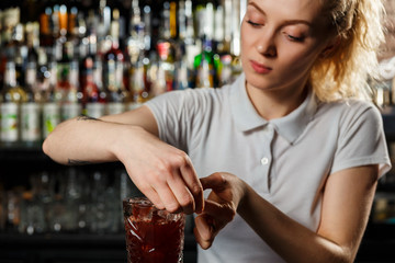 Woman bartender making an alcohol cocktail