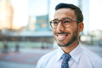 Indian businessman smiling confidently with cityscape background