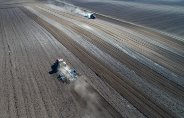 Tractors harrowing soil