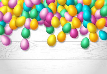 Easter frame with shiny colorful happy eggs spread over wooden background