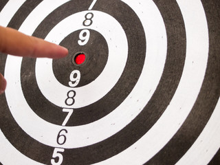 Black and white dart with hand point at center (Concept for target, achievement, business focus)