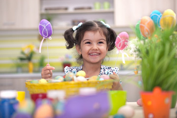 Cute little girl with basket full of colorful easter eggs