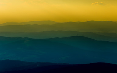 A beautiful, colorful, abstract mountain landscape with a hot summer haze in warm green tonality. Decorative, artistic look.
