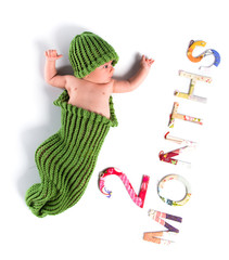 Cute newborn baby with a green disguise