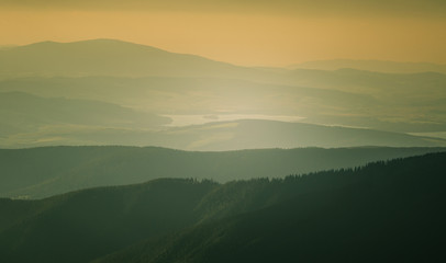 A beautiful, colorful, abstract mountain landscape with a hot summer haze in warm green tonality. Decorative, artistic look.