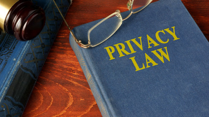 Book with title Privacy Law on a wooden surface. 