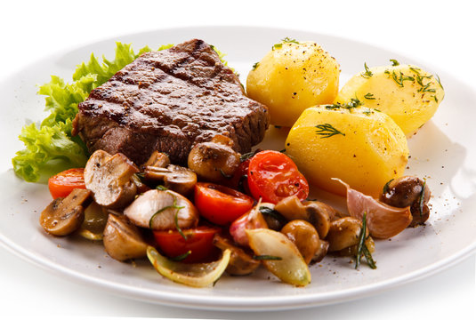 Roast steak with potatoes on white plate