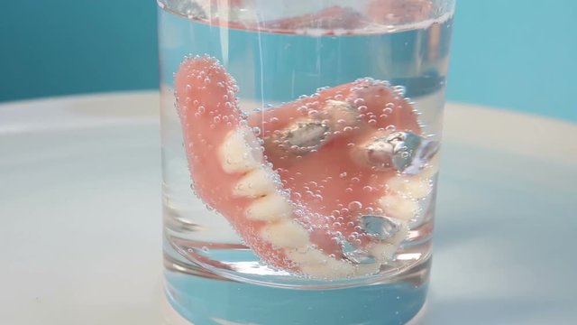 water glass with denture on rotating plate
