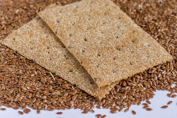 close up of flax seeds isolated and two slices of rye bread on white background
