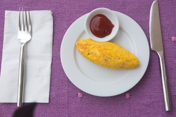 Hot omelet with tomato sauce in white dish