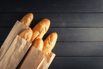 French baguettes with sesame seed on black wooden background