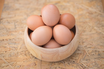 Egg in a wooden bowl on wooden table