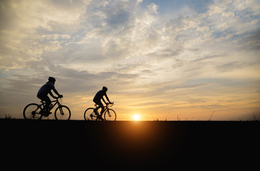 Silhouette of a woman and man  biker in the sunset