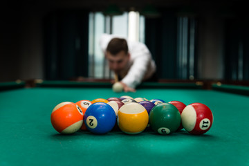 Billiards pool game, athlete with cue close-up, selective focus