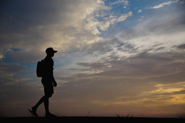 Silhouette of a man happy walking at sunset.