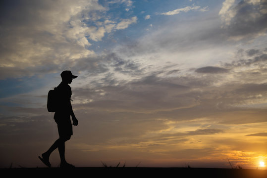 Silhouette of a man happy walking at sunset.