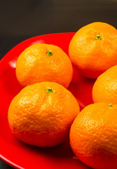 tangerines in a red plate