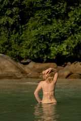 Young sexy woman sunbathing in sea or ocean