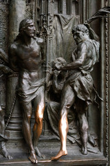 Scultura in bronzo sulla porta del duomo di Milano