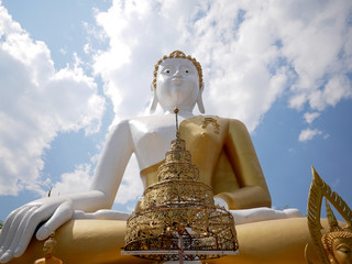 Fototapeta premium Low angle of giant Buddha statue at Wat Phra That Doi Kham (Temple of the Golden Mountain) in Chiang Mai, Thailand