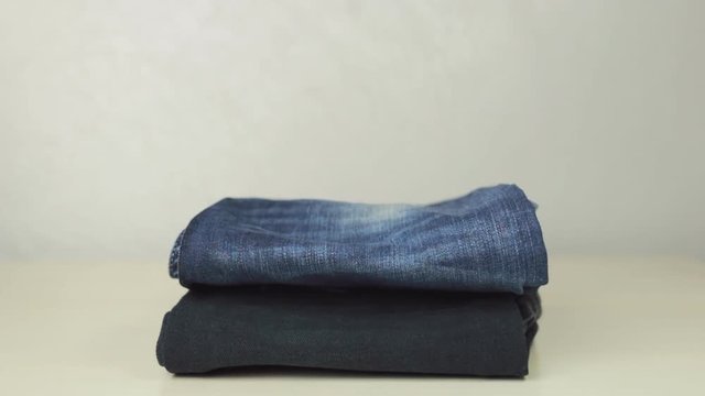 Female hands putting together blue denim jeans
