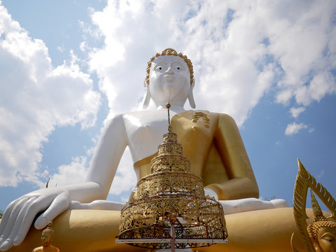 Low angle of giant Buddha statue at Wat Phra That Doi Kham (Temple of the Golden Mountain) in Chiang Mai, Thailand