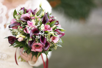 Composizione floreale colorata in mano a una sposa
