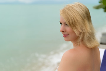 Fototapeta na wymiar Young blonde woman on a beach lounger